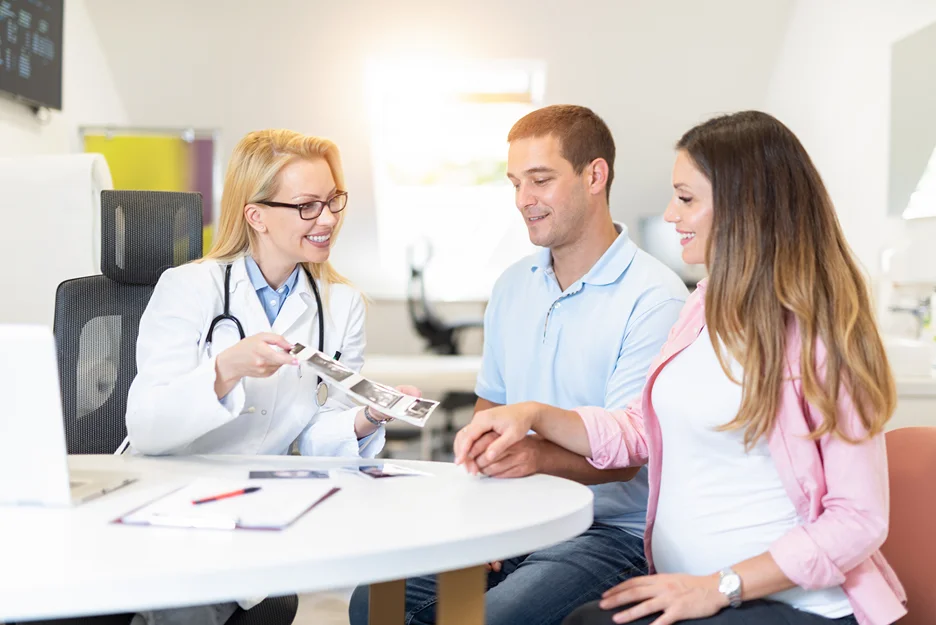 fertility doctor and a couple inside a clinic