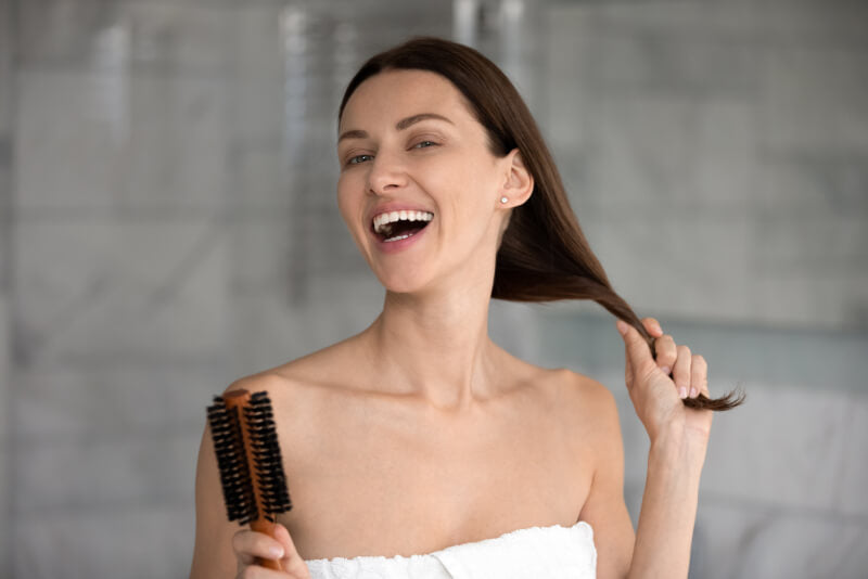 happy young woman holding her long dark hair
